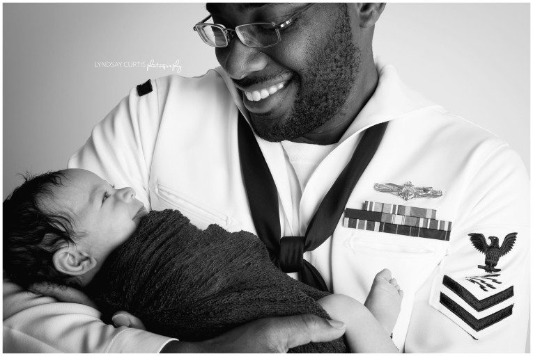 Portrait photographer Lyndsay Curtis photographs newborn girl with her U.S. Navy Sailor dad in dress whites in her in-home newborn studio. | www.lyndsaycurtis.com