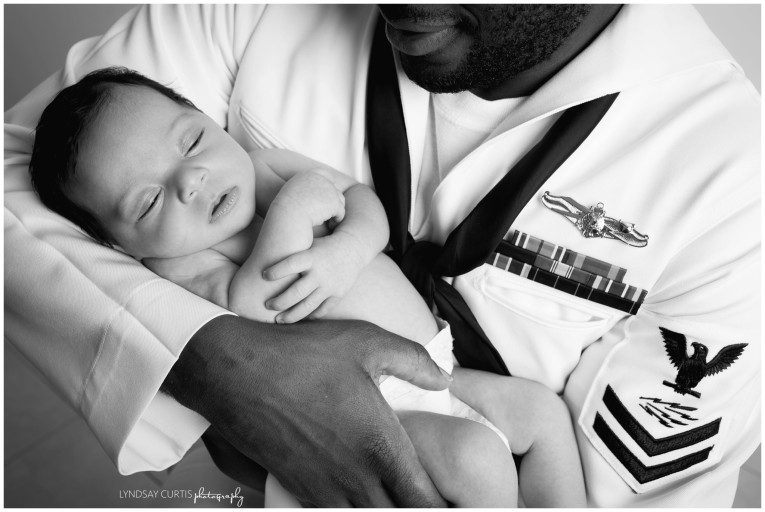 Portrait photographer Lyndsay Curtis photographs newborn girl with her U.S. Navy Sailor dad in dress whites in her in-home newborn studio. | www.lyndsaycurtis.com