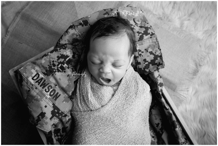 Portrait photographer Lyndsay Curtis photographs newborn girl with her dad's U.S. Military uniform in her in-home newborn studio. | www.lyndsaycurtis.com