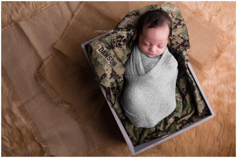 Portrait photographer Lyndsay Curtis photographs newborn girl with her dad's U.S. Military uniform in her in-home newborn studio. | www.lyndsaycurtis.com