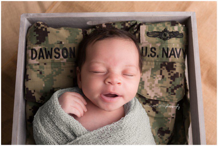 Portrait photographer Lyndsay Curtis photographs newborn girl with her dad's U.S. Navy uniform in her in-home newborn studio. | www.lyndsaycurtis.com