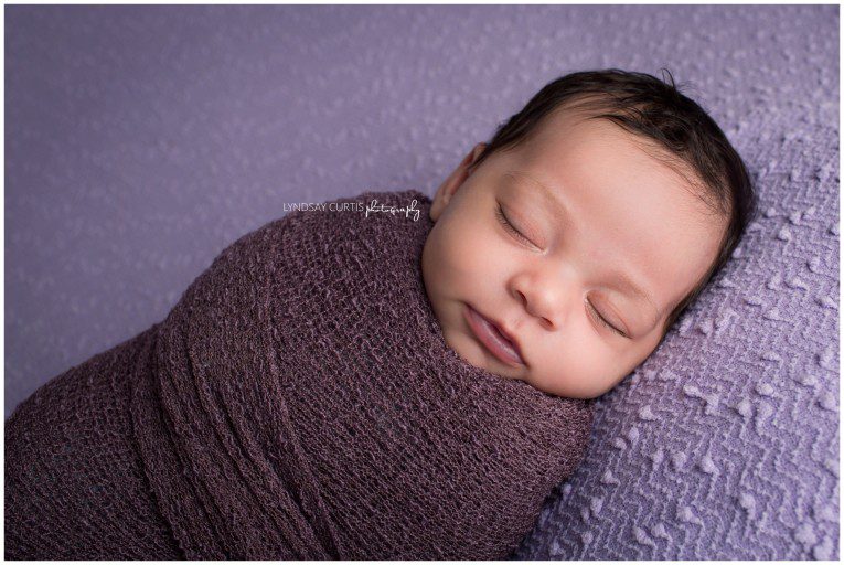 Portrait photographer Lyndsay Curtis photographs newborn girl in purple in her in-home newborn studio. | www.lyndsaycurtis.com