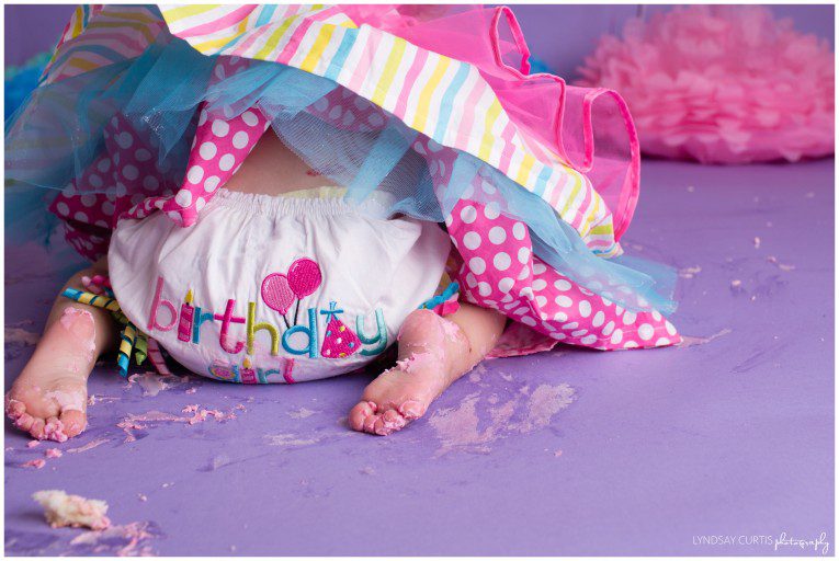 Portrait photographer Lyndsay Curtis photographs 1 year old birthday girl Campbell in her home studio during a pink, blue and purple cake smash session. | www.lyndsaycurtis.com
